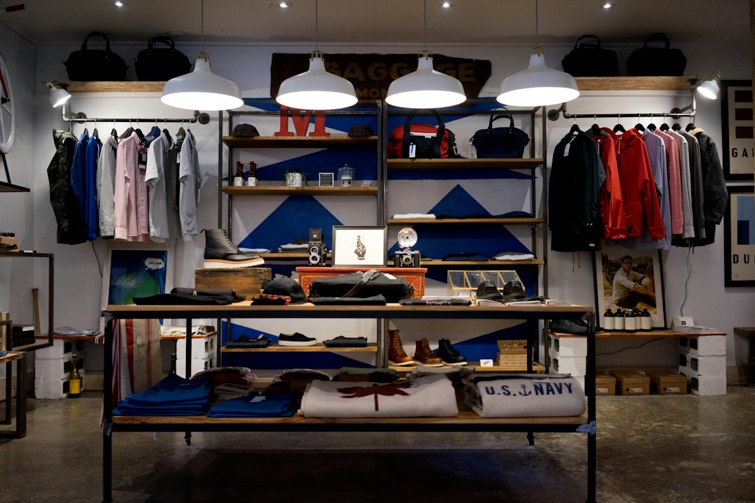 A retail store interior with staff arranging merchandise on open shelves